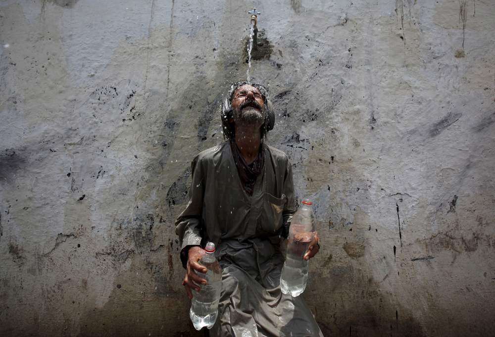 A man cools off from a public tap after filling bottles during intense hot weather in Karachi, Pakistan, June 23, 2015. REUTERS\/Akhtar Soomro&amp;nbsp;