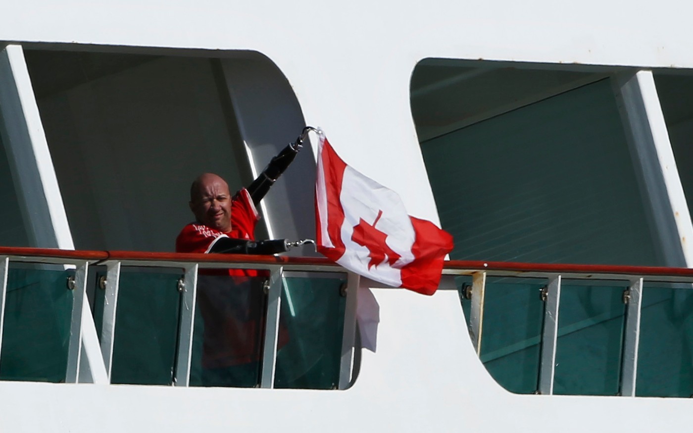 Man holds a Canadian flag upside down, as Royal Caribbean's Explorer of