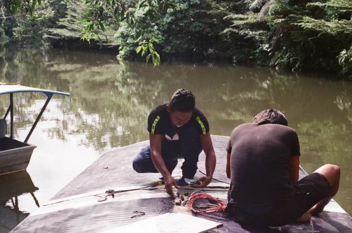 A group of Kara Solar technicians work on a new solar-panel-powered river boat near Tena, Ecuador, April 22, 2022. Thomson Reuters Foundation/Melissa Godin