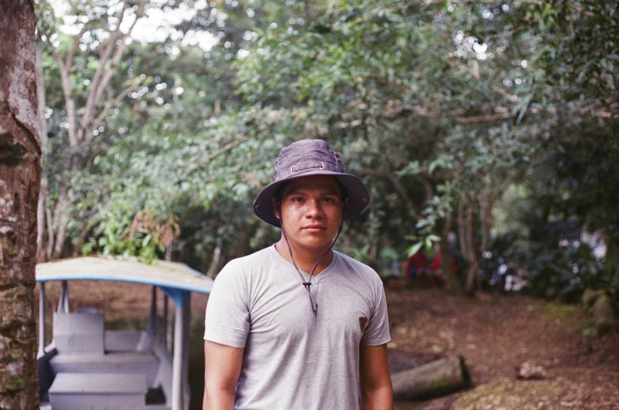 Oscar Mukucham, 22, an Achuar indigenous technician for Kara Solar, stands next to a new solar-panel-powered boat near Tena, Ecuador, April 22, 2022. Thomson Reuters Foundation/Melissa Godin