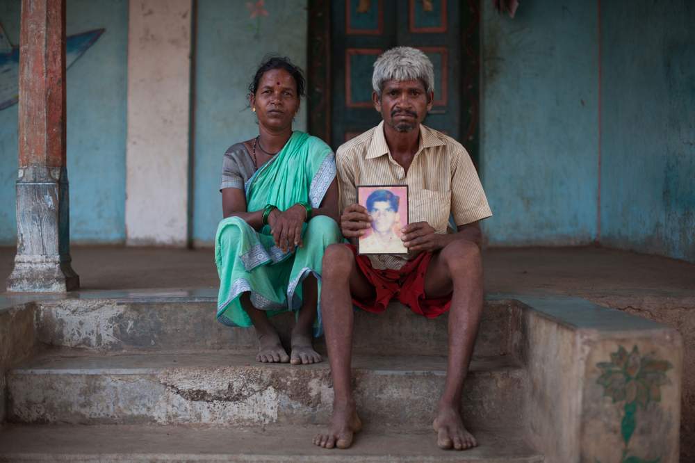 Chandrakant Shankar Meghwani and his wife Chandrakala pose with a picture of their son Mahesh who died while extracting sand.
