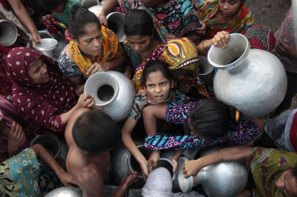 People holding water pots jostle as they collect water on the outskirts of Dhaka, May 28, 2012. REUTERS\/Andrew Biraj 