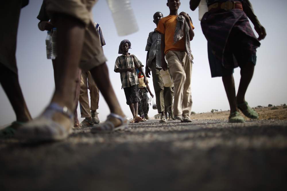Ethiopian migrants walk on the side of a highway leading to the western Yemeni town of Haradh on the border with Saudi Arabia, March 28, 2012. REUTERS\/Khaled Abdullah