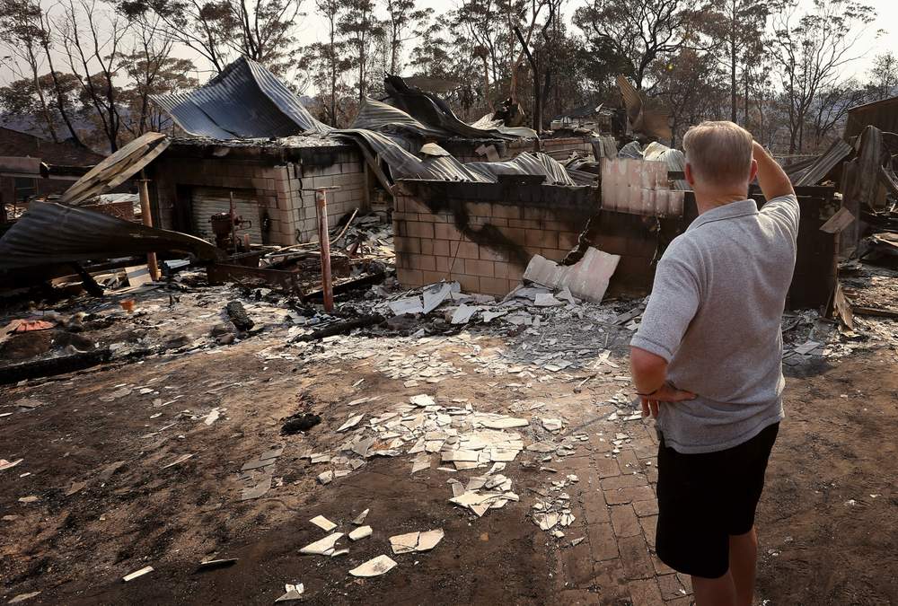 Colin Smith looks at the remains of his family&#39;s house after it was destroyed by a bushfire in the Blue Mountains suburb of Winmalee, located around 70 km west of Sydney, October 21, 2013. REUTERS\/David Gray  