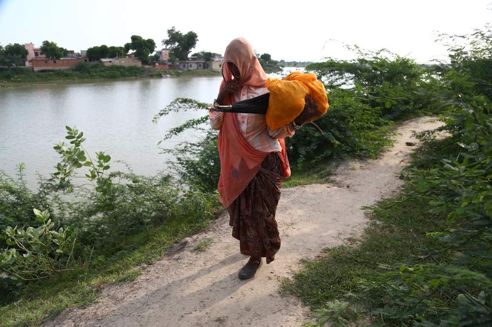 A woman walks beside a water reservoir in Soda village, Rajasthan, India.