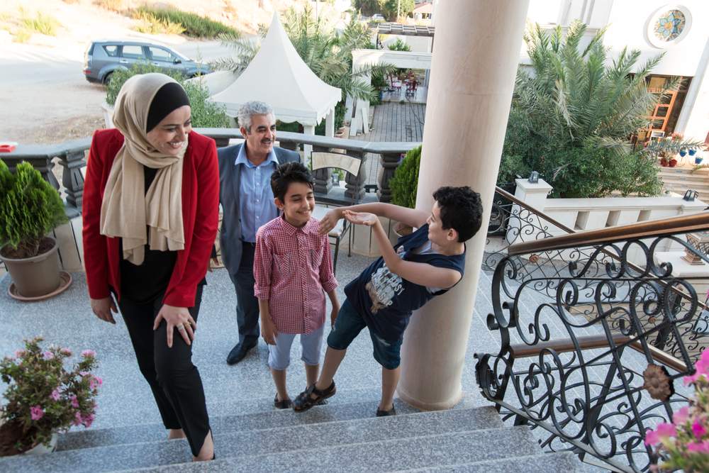 MP Wafa Bani Mustafa poses for a photo with her husband and two kids in Jerash, Jordan.